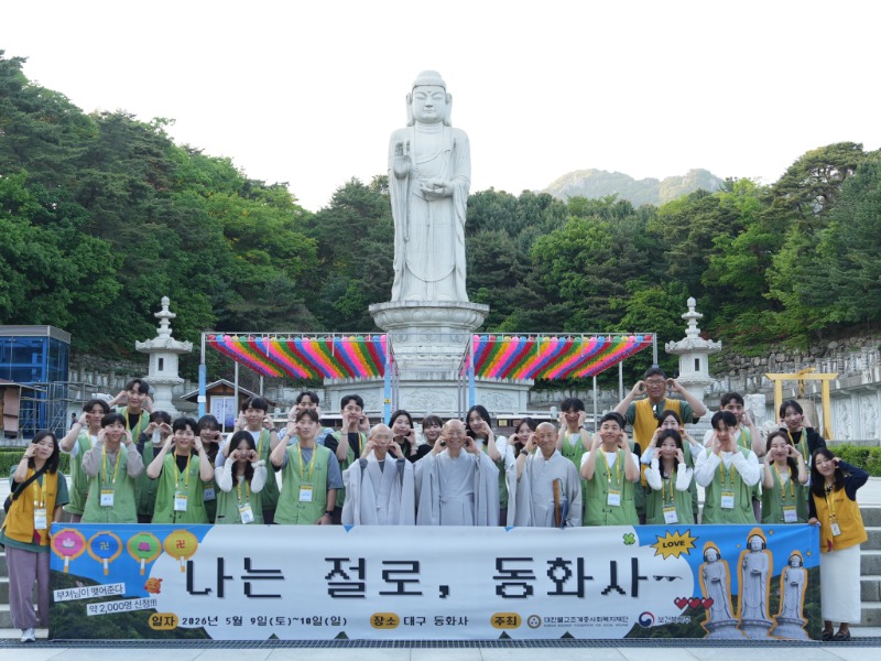 참가자들이 동화사 통일대불 앞에서 시그니처 포즈 볼하트를 하며 단체사진을 촬영하는 모습.JPG